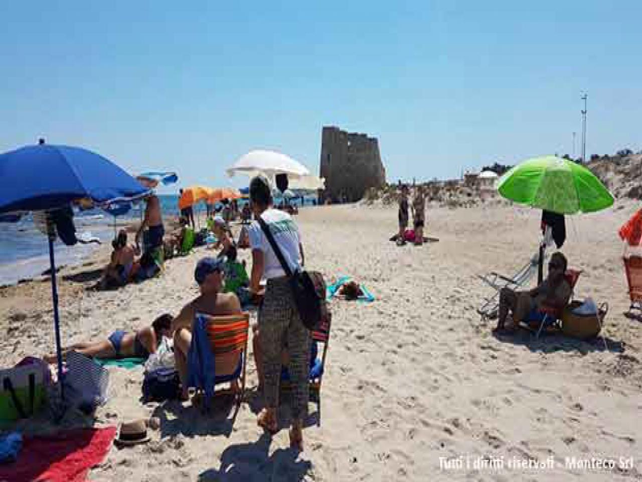 donna che sensibilizza persone al mare sulla differenziata