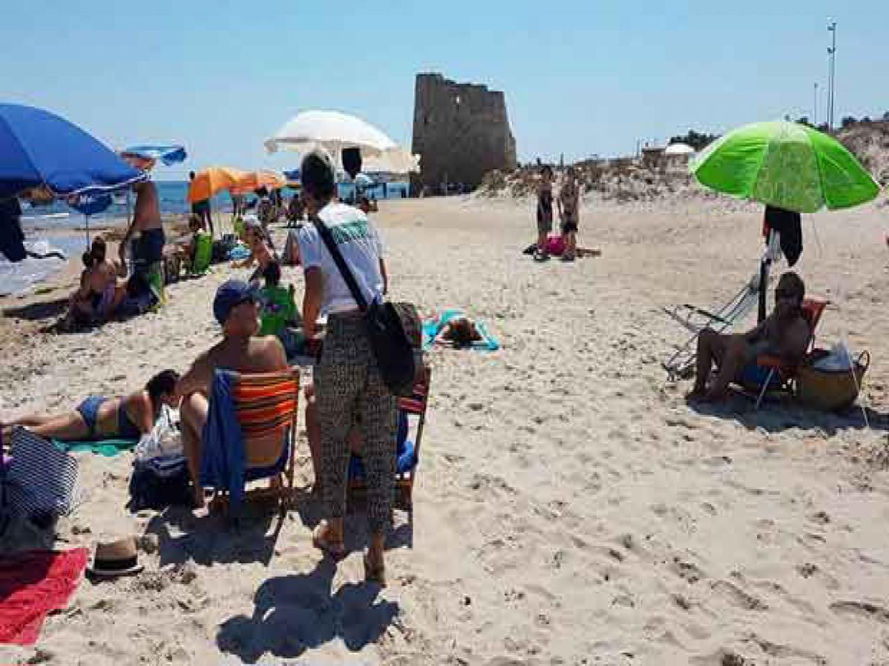 donna che sensibilizza persone al mare sulla differenziata