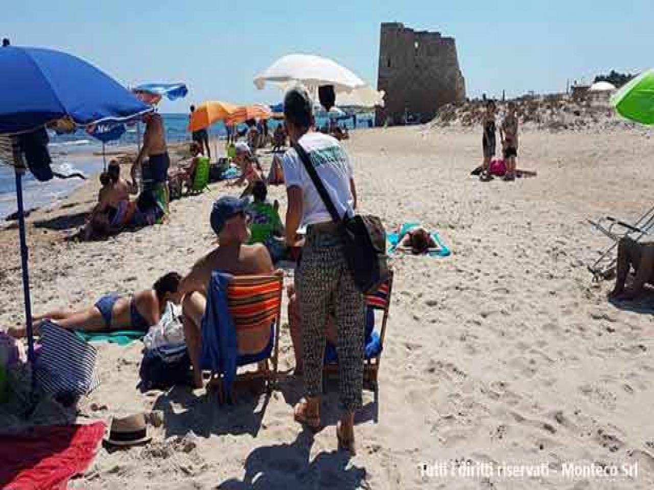 donna che sensibilizza persone al mare sulla differenziata